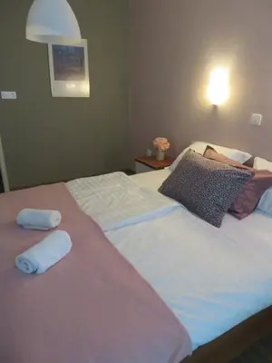 a bedroom with a large bed with two towels on it at Sobe ob Sotočju Budič Čatež ob Savi in Brežice