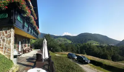 a balcony of a building with cars parked on a hill at Pod Orehi Guest House in Loče pri Poljčanah