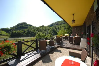a patio with a table and chairs on a balcony at Pod Orehi Guest House in Loče pri Poljčanah