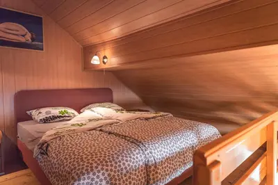 a bedroom with a bed in a wooden room at Vineyard Cottage Urban in Mirna