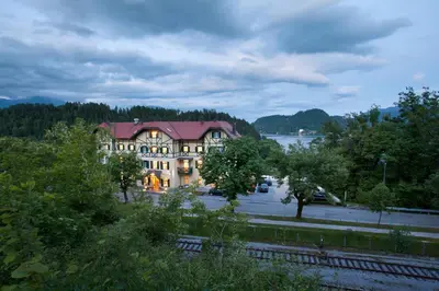 a large house with a river in front of it at Hotel Triglav in Bled