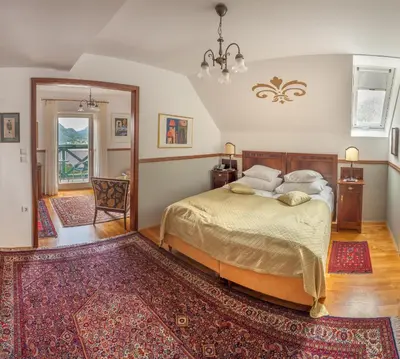 a bedroom with a bed and a rug at Hotel Triglav in Bled