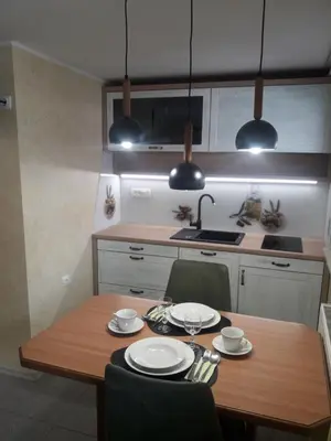a kitchen with a wooden table with chairs and a sink at Apartments Vesna in Bled