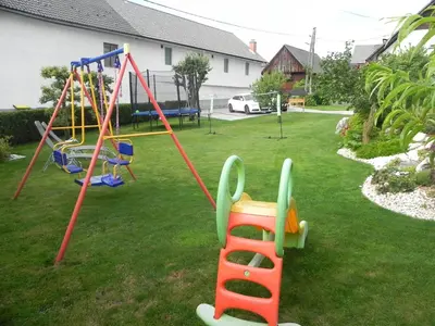 a yard with a playground with a swing at Apartments Vesna in Bled