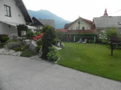 a yard with a garden with rocks and a house at Apartments Vesna in Bled