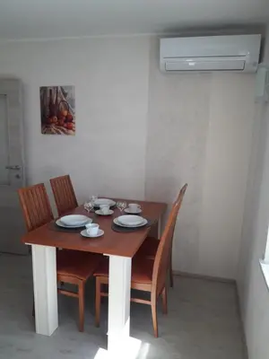 a dining room table with chairs and a wooden table and a fan at Apartments Vesna in Bled