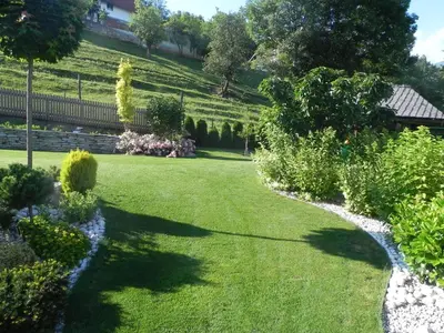 a garden with green grass and trees and bushes at Apartments Vesna in Bled