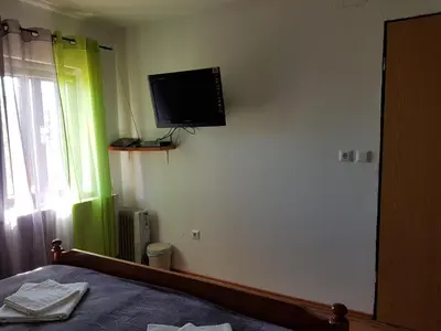 a bedroom with a flat screen tv on the wall at Vaznik Farm House Apartments in Bled