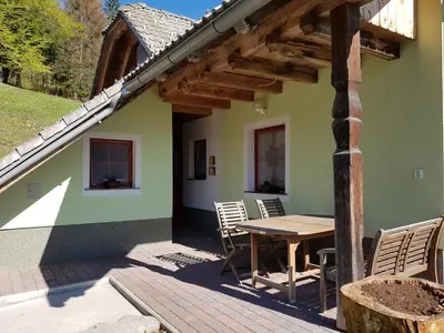 a patio of a house with a table and chairs at Vaznik Farm House Apartments in Bled