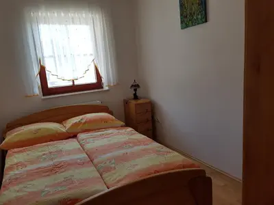 a small bedroom with a bed and a window at Vaznik Farm House Apartments in Bled