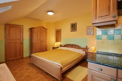a bedroom with a bed with yellow walls and wooden floors at Eco Tourist Farm Ravnjak in Slovenj Gradec