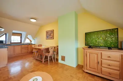 a kitchen and dining room with a large flat screen tv at Eco Tourist Farm Ravnjak in Slovenj Gradec