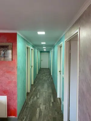 an empty hallway with colorful walls and wooden floors at Apartman Decorus in Maribor