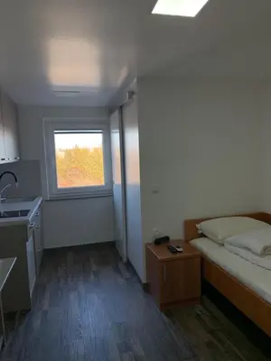 a small bedroom with a bed and a window at Apartman Decorus in Maribor