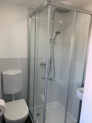 a bathroom with a glass shower with a toilet at Apartman Decorus in Maribor