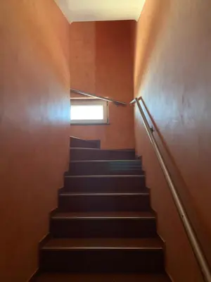 a staircase in a building with a stair railing and a window at Apartman Decorus in Maribor