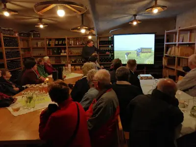 a group of people sitting around a table watching a presentation at Beekeeping Kojek in Ribnica