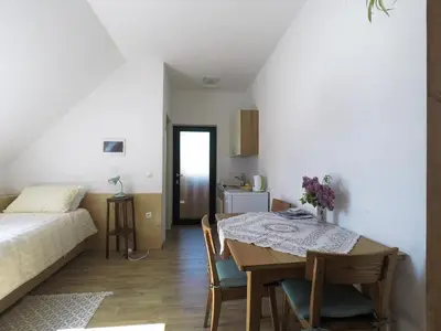 a room with a table and a bed and a bedroom at Beekeeping Kojek in Ribnica