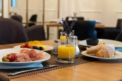a table with plates of food and a glass of orange juice at Hotel Starkl - Heritage & Unique in Bled