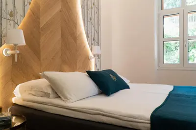 a bed with two pillows on it in a room at Hotel Starkl - Heritage & Unique in Bled