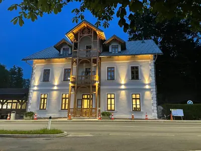 a large white building with a balcony on a street at Hotel Starkl - Heritage & Unique in Bled