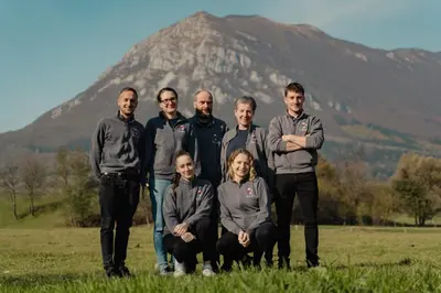 a group of people posing in front of a mountain at EkoTurizem Hudičevec in Postojna
