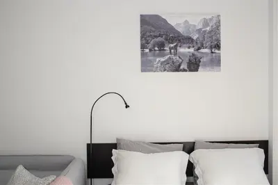 a bedroom with a couch and a picture of a river at Apartment Obsidian & Pearl in Kranjska Gora