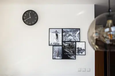 a clock on a wall with pictures on it at Apartment Obsidian & Pearl in Kranjska Gora