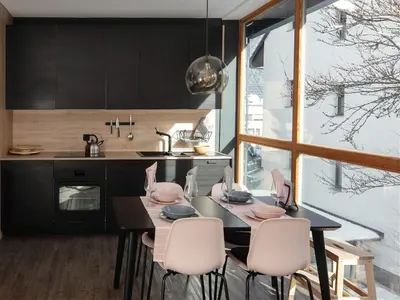 a kitchen with a black table and white chairs at Apartment Obsidian & Pearl in Kranjska Gora