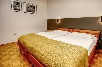 a bedroom with two twin beds with white sheets at Primula Accommodation in Nova Gorica