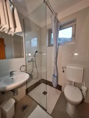 a bathroom with a shower and a toilet and a sink at Primula Accommodation in Nova Gorica