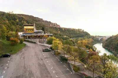 a building on the side of a road next to a river at Primula Accommodation in Nova Gorica
