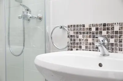 a bathroom with a sink and a shower with a mirror at Primula Accommodation in Nova Gorica