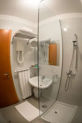 a bathroom with a glass shower and a sink at Primula Accommodation in Nova Gorica