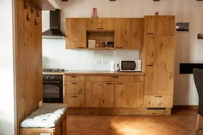 a kitchen with wooden cabinets and a microwave at Mulberry house in Šempas