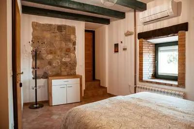 a bedroom with a bed and a stone wall at Mulberry house in Šempas