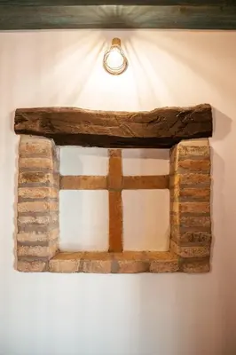 a reclaimed wood window frame on a wall with a light at Mulberry house in Šempas