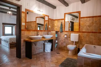 a bathroom with two sinks and a tub and a toilet at Mulberry house in Šempas