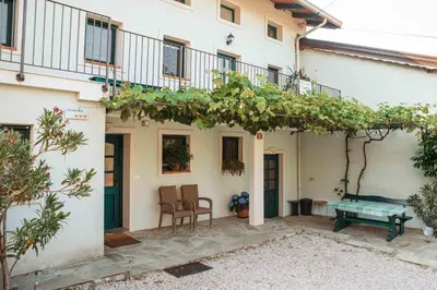 a patio with a table and a bench in front of a building at Mulberry house in Šempas