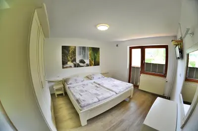 a small bedroom with a bed and a window at Apartments Arh in Bohinj
