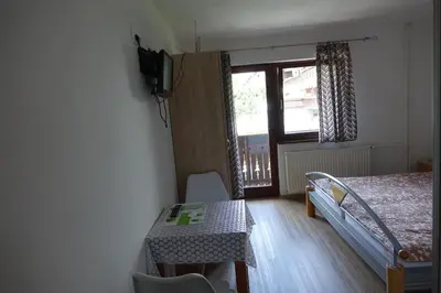 a bedroom with a bed and a table and a window at BOOA Rooms Irena in Bohinj