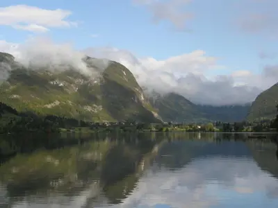 a view of a mountain reflecting in a lake at BOOA Rooms Irena in Bohinj