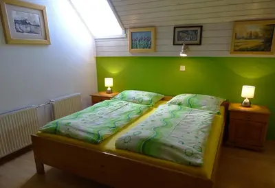 a bedroom with two twin beds with green walls at Apartments Zorč in Bohinj