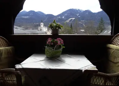 a table with a basket of flowers on top of a window at Apartments Zorč in Bohinj