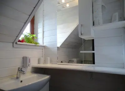 a white bathroom with a sink and a window at Apartments Zorč in Bohinj