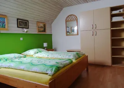 a bedroom with a bed with a green wall at Apartments Zorč in Bohinj