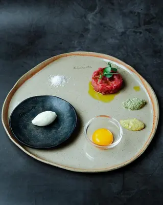 a plate of food with an egg on a table at Bužinel Estate in Dobrovo