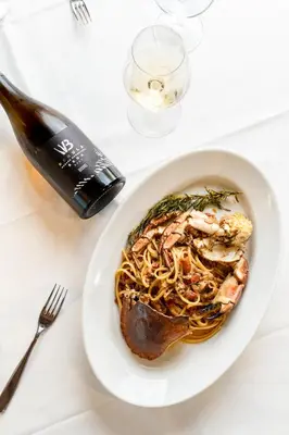 a plate of pasta with shrimp and meat on a table at Bužinel Estate in Dobrovo