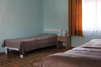 a bedroom with two beds and a table and a window at Apartma Lipa in Mojstrana