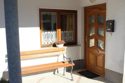 a bench in front of a building with a door at Apartma Lipa in Mojstrana